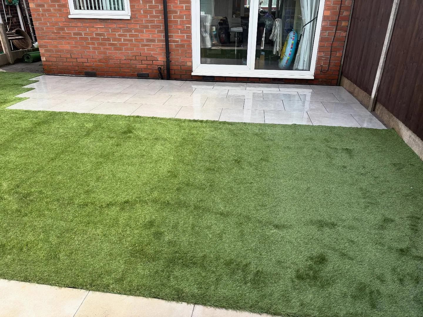 Completed rear garden with green lawn and a pale paved patio